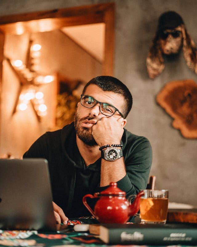 Man sitting with his face propped on his fist, with an expression of just being completed over this and checked out
